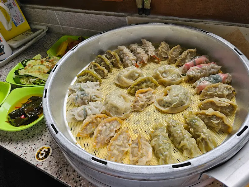 다양한 만두와 곁들임 찬이 함께 놓인 테이블