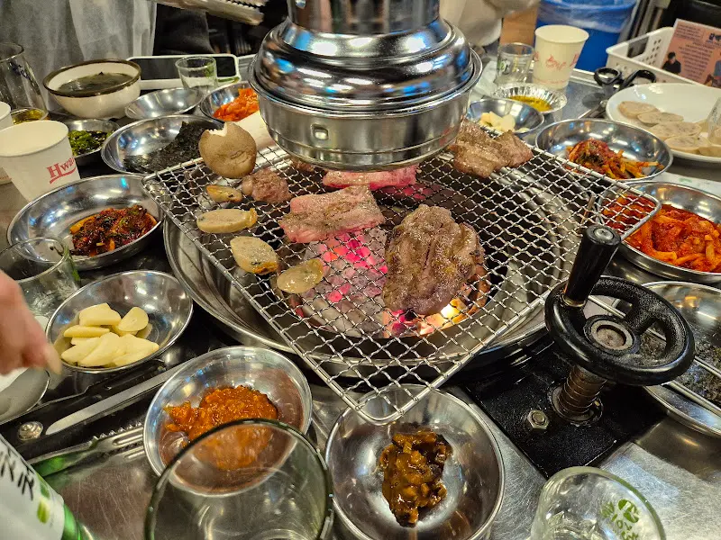 숯불과 환풍기, 그리고 테이블 가득한 밑반찬