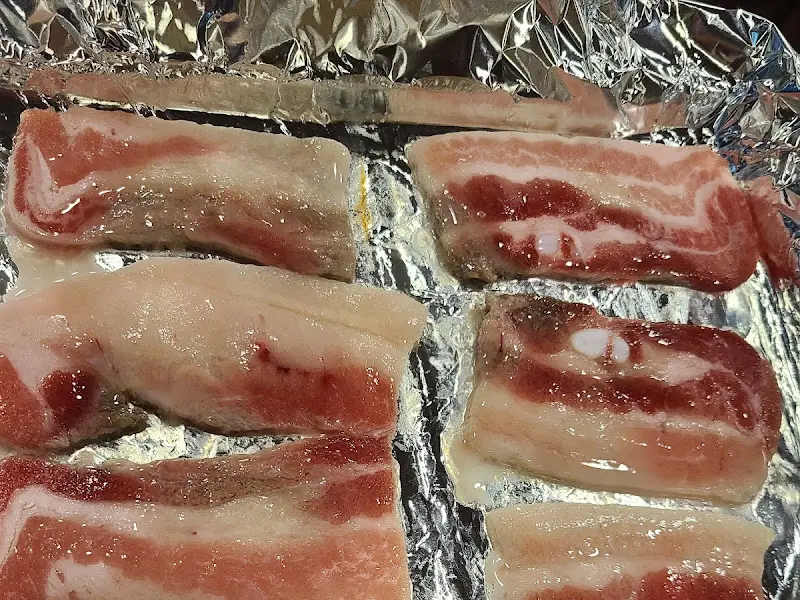 불판 위에 올려진 냉동 삼겹살