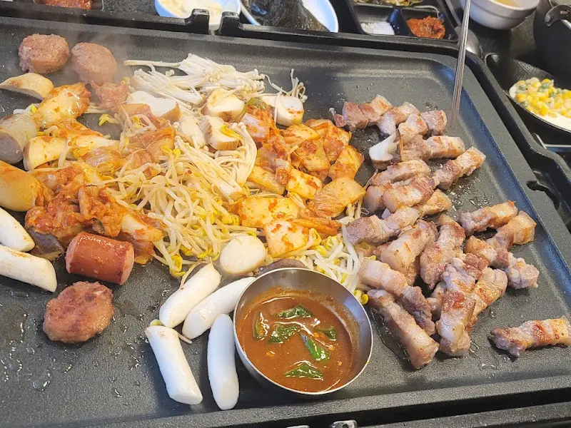 돌판 위에 푸짐하게 차려진 삼겹살 한 상