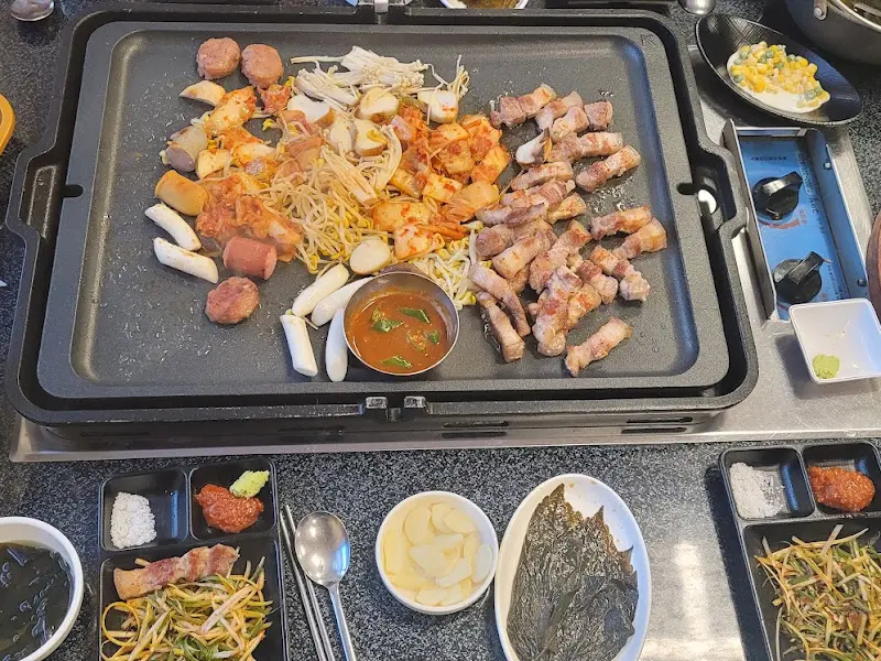 돌판 위에 올려진 다양한 곁들임과 삼겹살