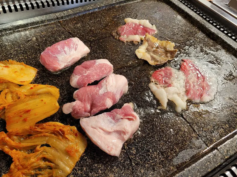 돌판 위에서 익어가는 오겹살과 김치