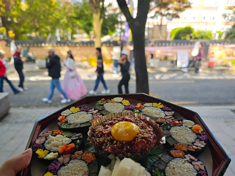 보석육회김밥을 들고 한옥마을을 배경으로