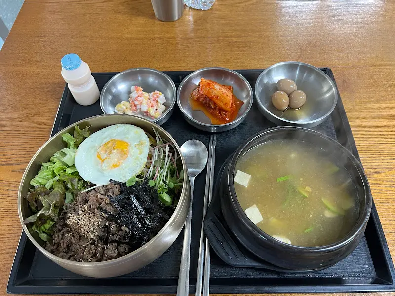 불고기 비빔밥 한 상 차림 사진. 비빔밥과 함께 정갈한 밑반찬과 된장찌개가 제공된다.