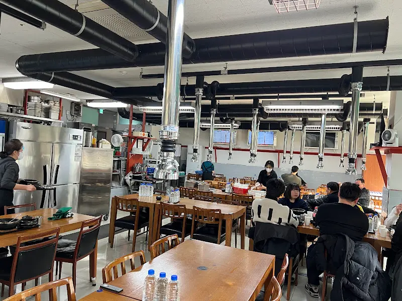 식당 내부 전경 사진. 깔끔하고 넓은 공간에 테이블이 정돈되어 있다.