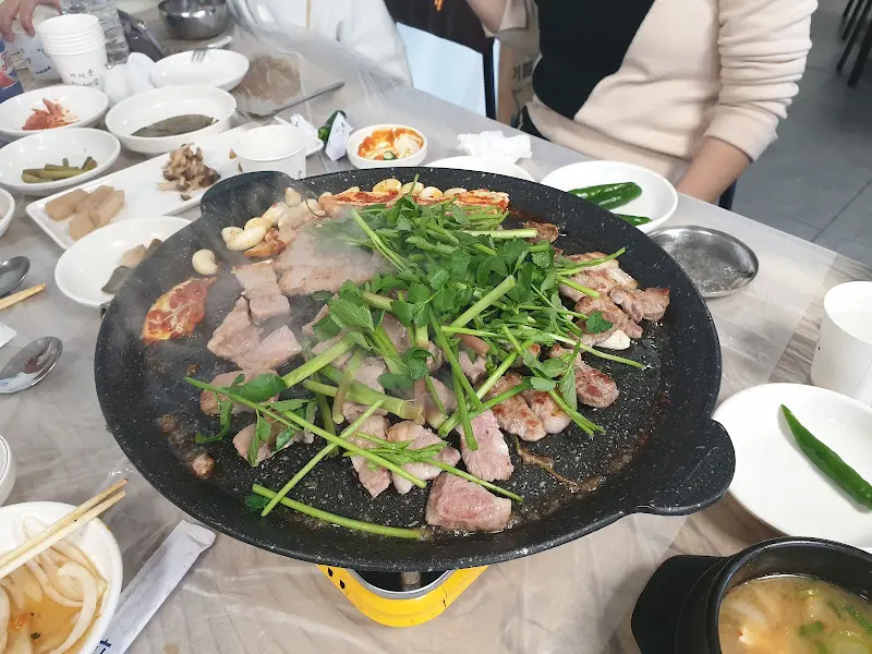 철판에 구워 먹는 돼지고기와 다양한 домашний стиль 반찬들