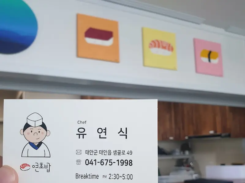 벽에 걸린 초밥 그림과 유연식 쉐프의 명함