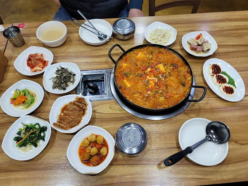 두부두루치기와 다양한 반찬이 놓인 테이블 전경