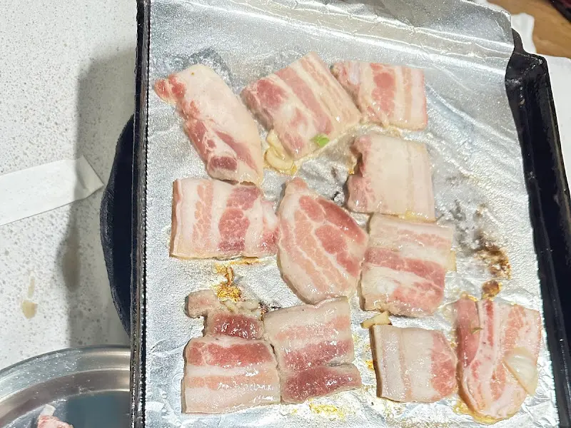 불판 위에서 맛있게 익어가는 냉동 삼겹살