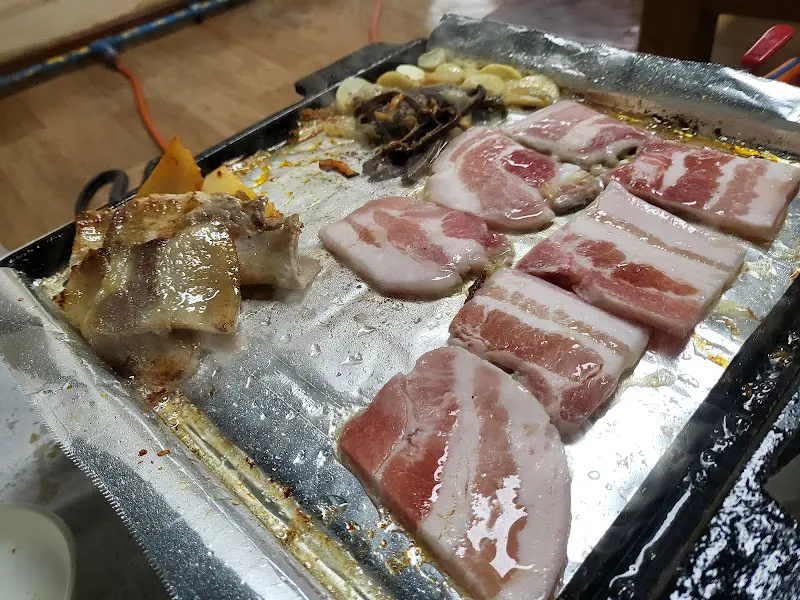 불판 위에서 익어가는 고기와 마늘