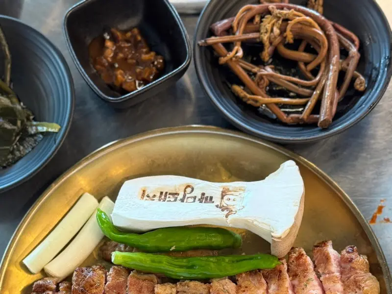 흑돼지와 함께 제공되는 다양한 소스와 밑반찬 클로즈업 사진.