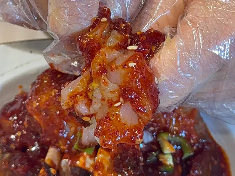 양념게장을 손으로 들고 먹는 모습