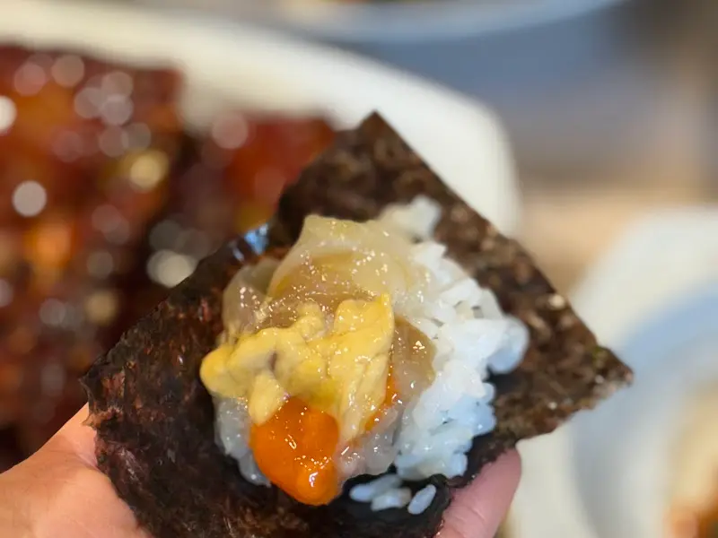 김에 밥과 게살을 함께 싸먹는 모습