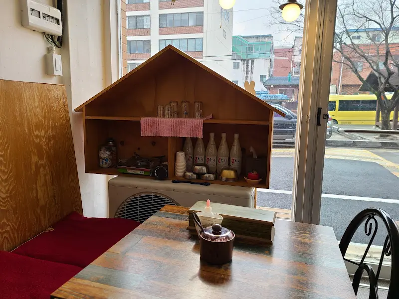 정갈한 나무 테이블과 따뜻한 햇살이 들어오는 창가 자리