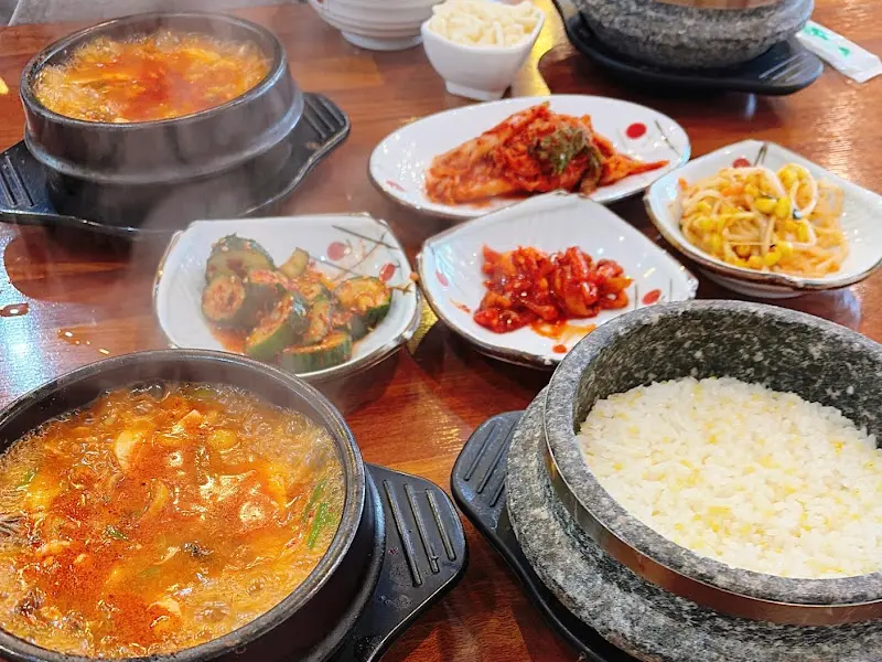 해물 순두부 찌개와 돌솥밥, 그리고 다양한 밑반찬이 차려진 식탁