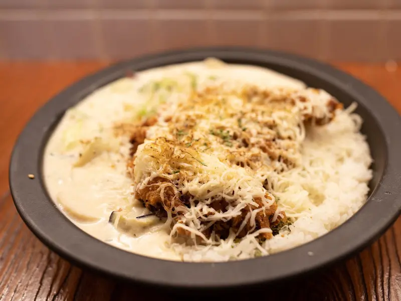 크림 카레 돈까스 전체 사진. 돈까스와 밥 위에 크림 카레 소스가 듬뿍 올려져 있다.