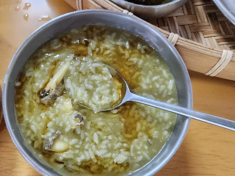 숟가락으로 전복죽을 떠올리는 모습