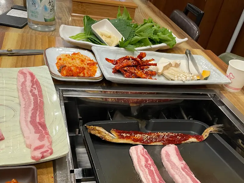 불판 위에서 구워지는 황태구이와 삼겹살