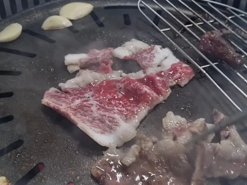 숯불 위에서 익어가는 안창살과 마늘