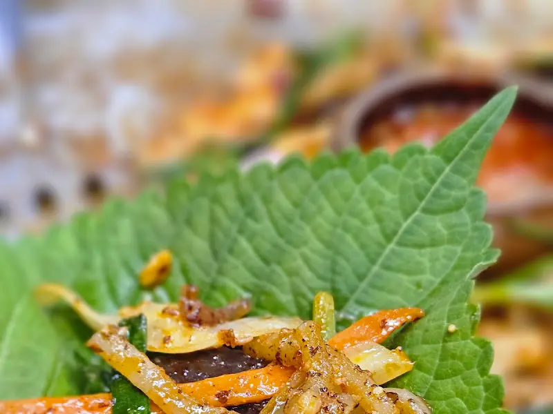 깻잎 위에 양념순대를 올려 쌈을 싸 먹는 모습