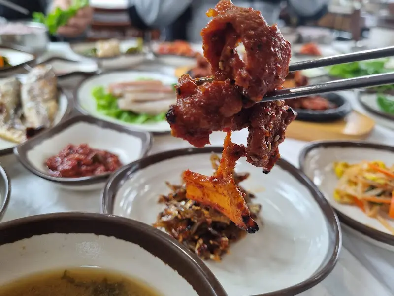 젓가락으로 집어 올린 돼지고기 주물럭