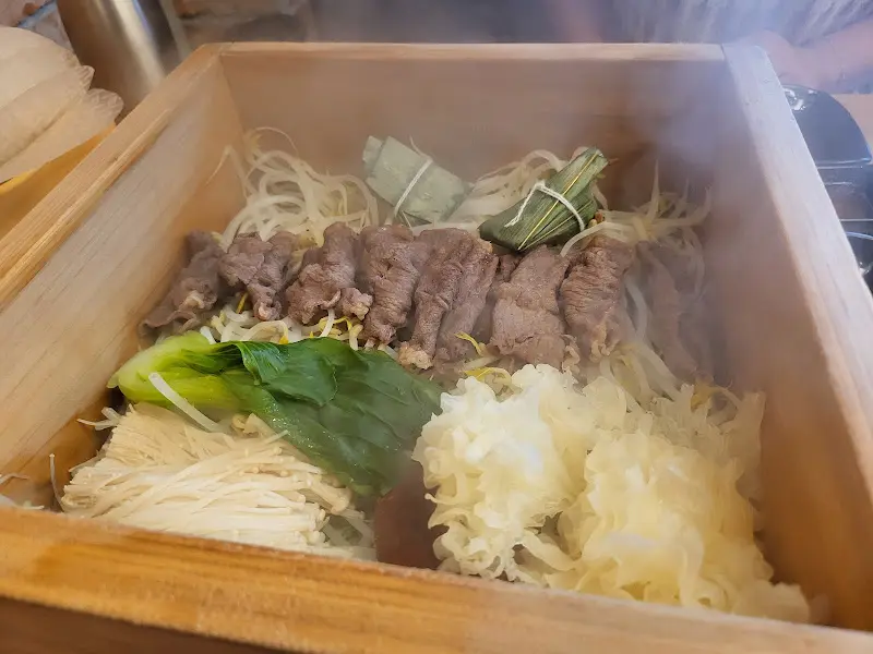 편백찜 나무 상자 안에는 김이 모락모락 피어오르는 소고기와 신선한 야채들이 담겨 있다.