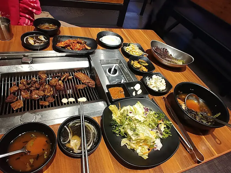 초벌된 돼지갈비와 다양한 밑반찬이 테이블을 가득 채운 모습