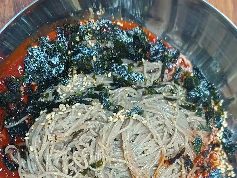 고소한 김가루와 깨가 듬뿍 뿌려진 비빔 막국수