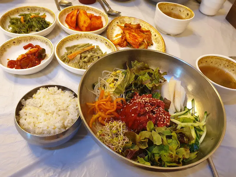 푸짐하게 차려진 육회비빔밥과 반찬들