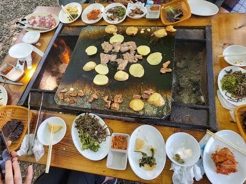 돌판 위에 구워지는 닭고기와 감자