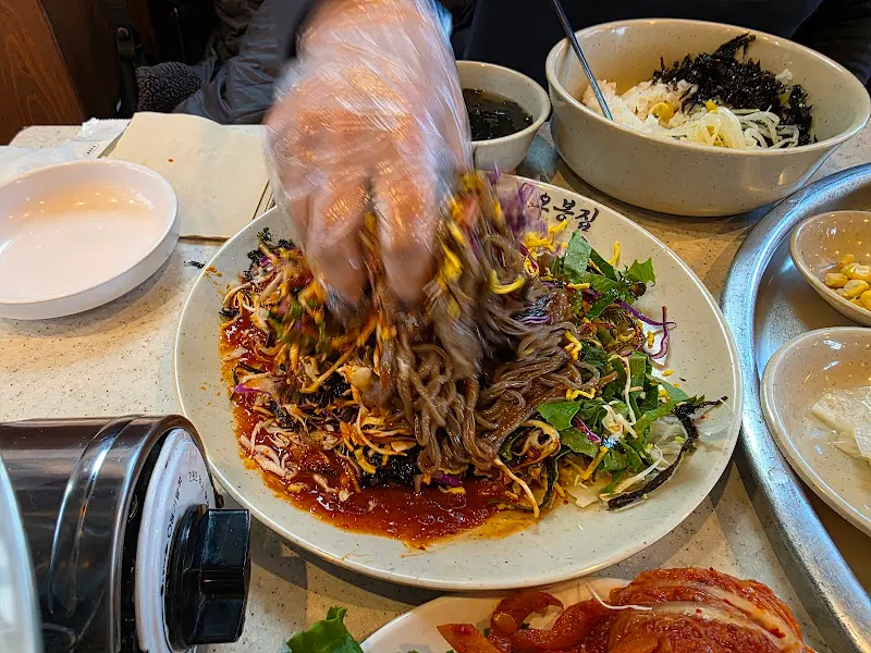 막국수를 비비는 역동적인 모습