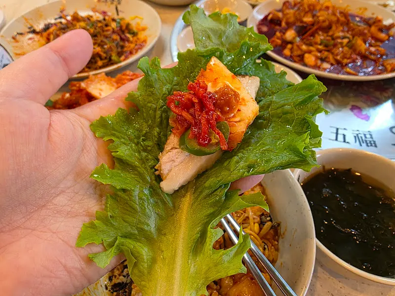 상추쌈에 보쌈과 낙지볶음을 함께 싸먹는 모습