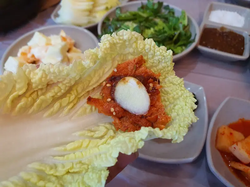 닭불고기를 배추에 싸서 먹는 모습