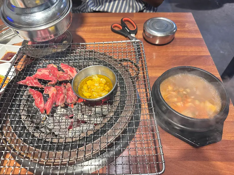 숯불 위에 구워지는 마늘 갈비와 된장찌개