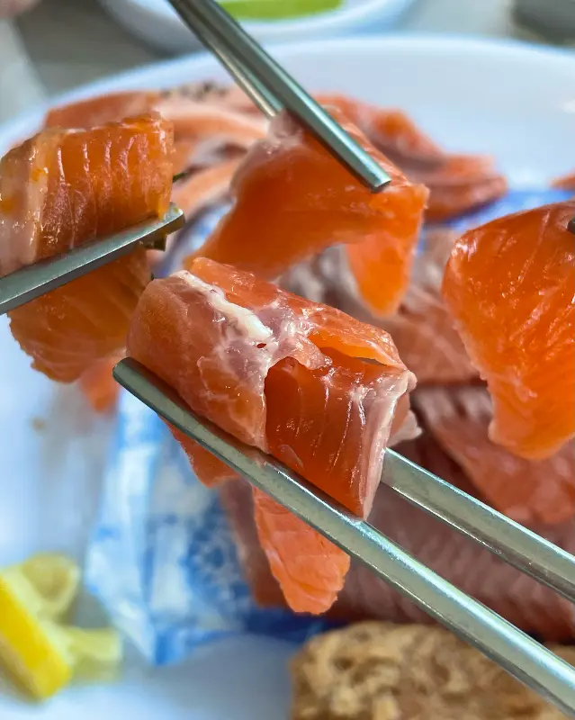 젓가락으로 집어 올린 송어회