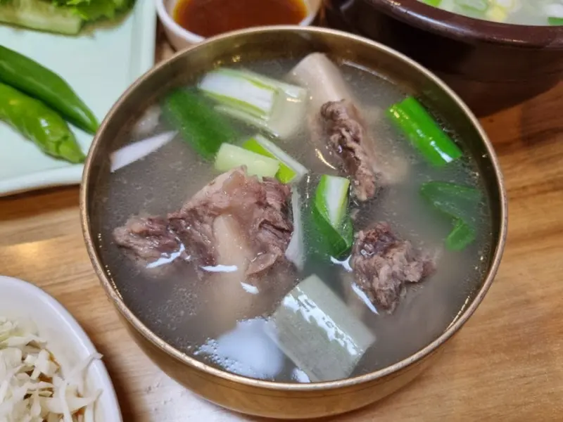 곰탕 국물에 파가 송송 썰어져 있다
