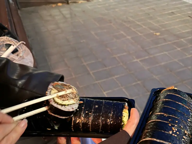 젓가락으로 김밥을 집는 모습