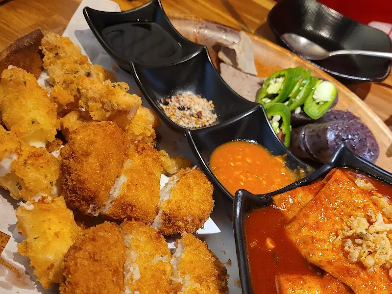 튀김과 떡볶이, 그리고 곁들여 먹을 수 있는 다양한 음식들이 담겨 있는 모습