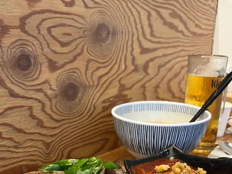 나무 테이블 위에 놓인 떡볶이와 맥주