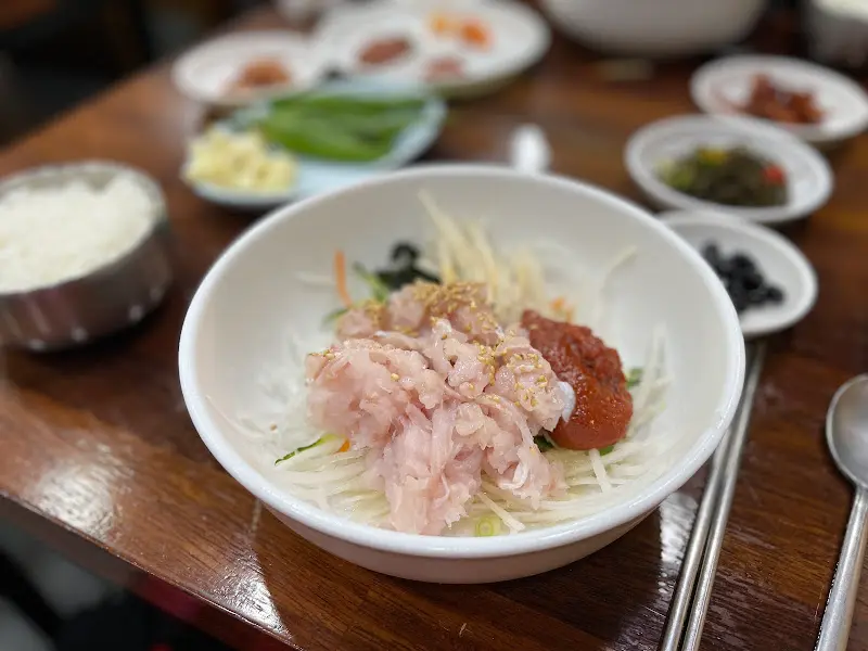 물회에 밥을 비빈 모습. 붉은 양념이 밥알에 스며들어 먹음직스럽다.