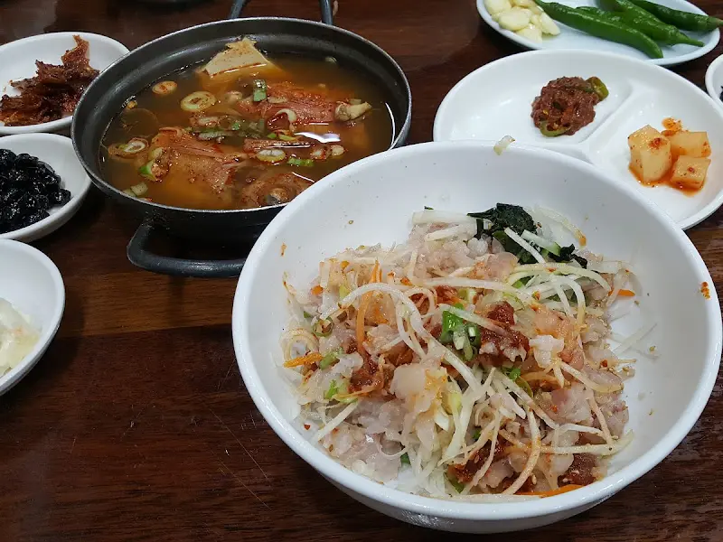 물회와 매운탕, 밑반찬이 함께 놓여 있는 모습. 푸짐한 한 상 차림이다.