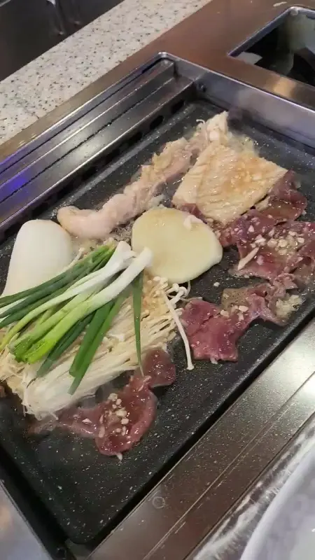 숯불 위에서 익어가는 곱창과 채소