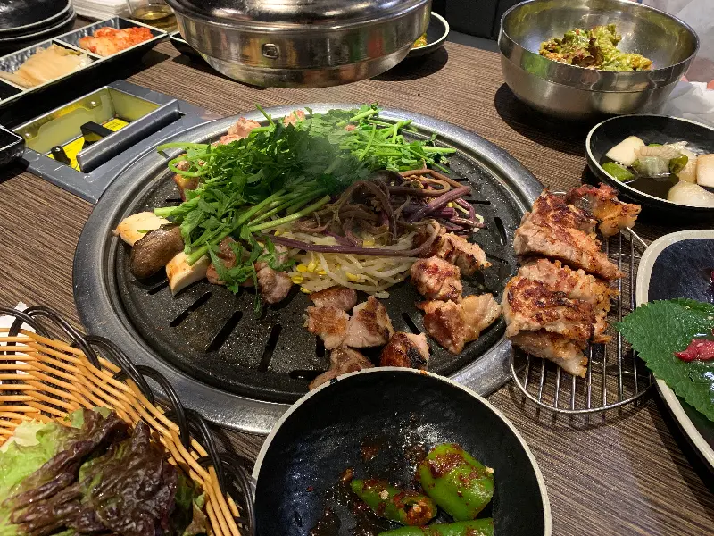 불판 가득 올려진 삼겹살과 미나리