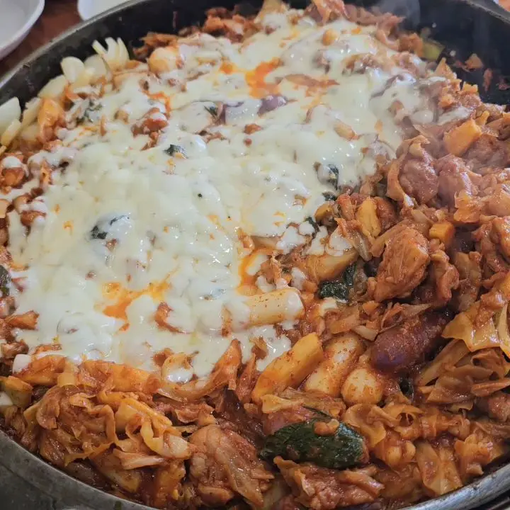 닭갈비 위에 녹아내린 치즈 토핑의 환상적인 비주얼