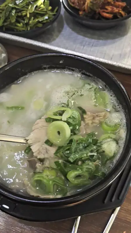 국밥에 다진 양념과 부추를 넣어 먹는 모습