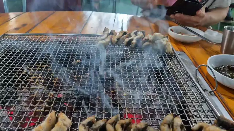 숯불 위에서 연기를 내며 구워지는 장어