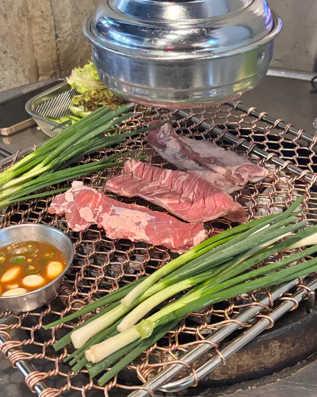 불판 위에서 익어가는 생갈매기살과 쪽파