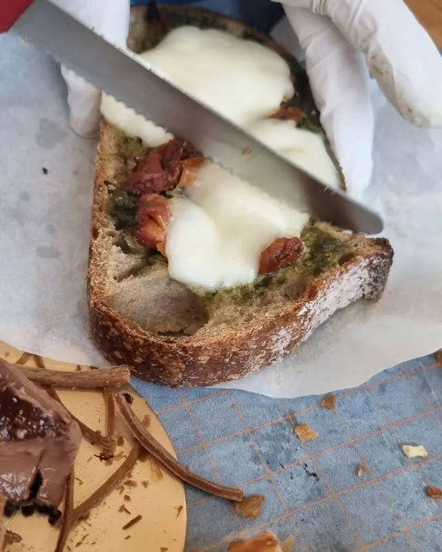 빵에 바질페스토와 치즈를 올려 먹는 모습
