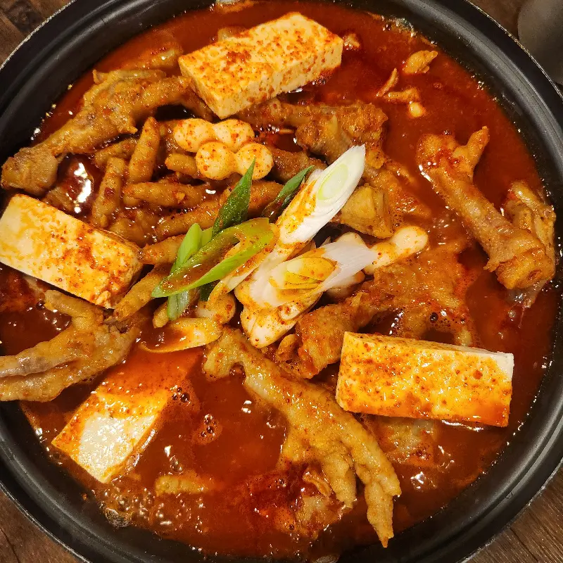 매콤한 양념이 듬뿍 묻은 닭발의 클로즈업 사진. 보기만 해도 침샘을 자극한다.