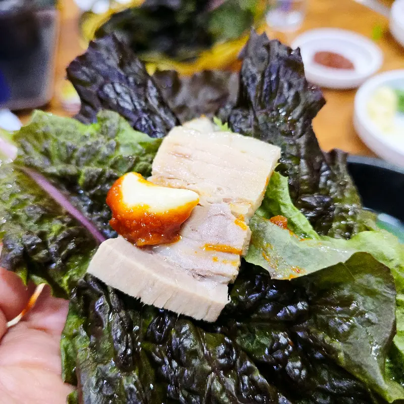 상추쌈에 수육, 쌈장, 김치를 듬뿍 올려 한 입 가득